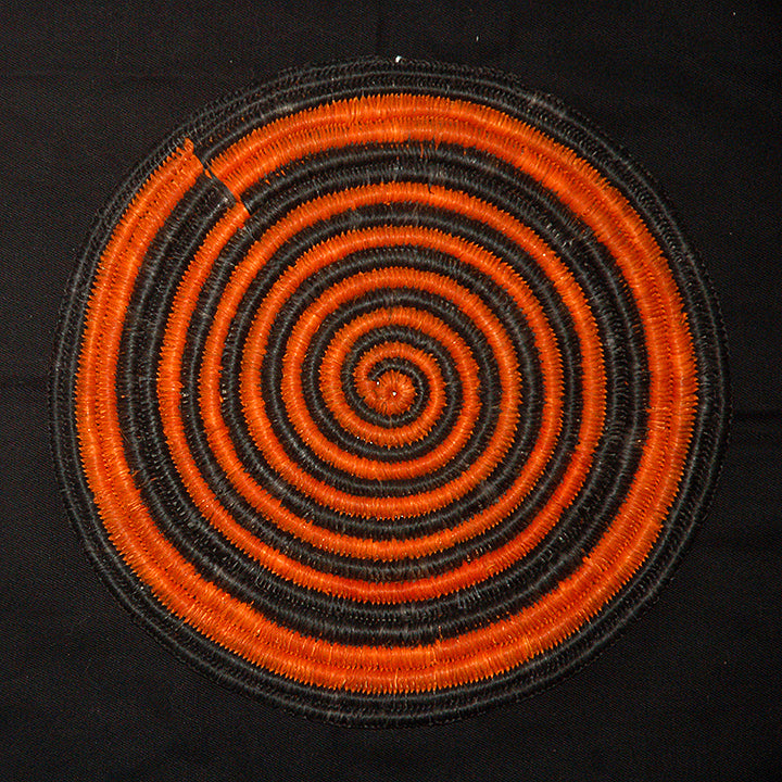 Woven hot pad (trivet) and center piece with black and orange spirals