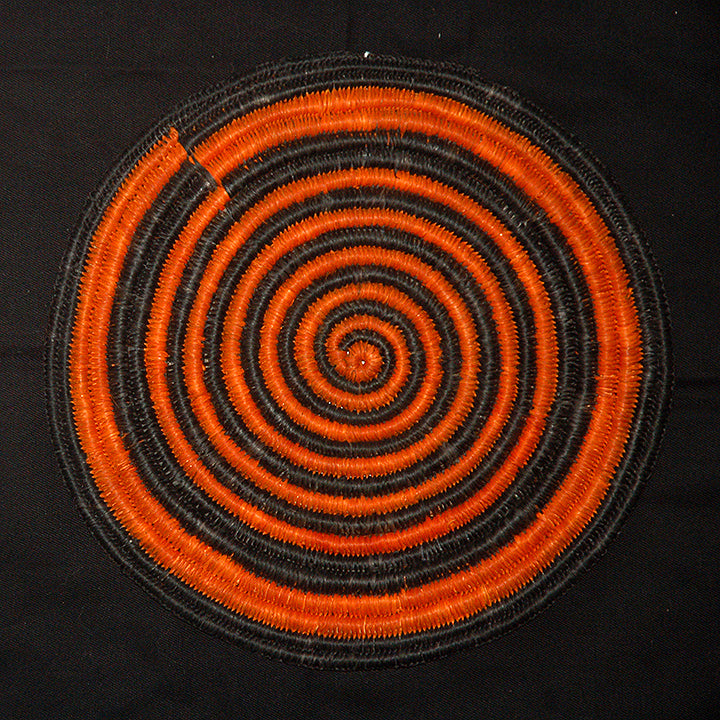 Woven hot pad (trivet) and center piece with black and orange spirals - Amazon Ecology
